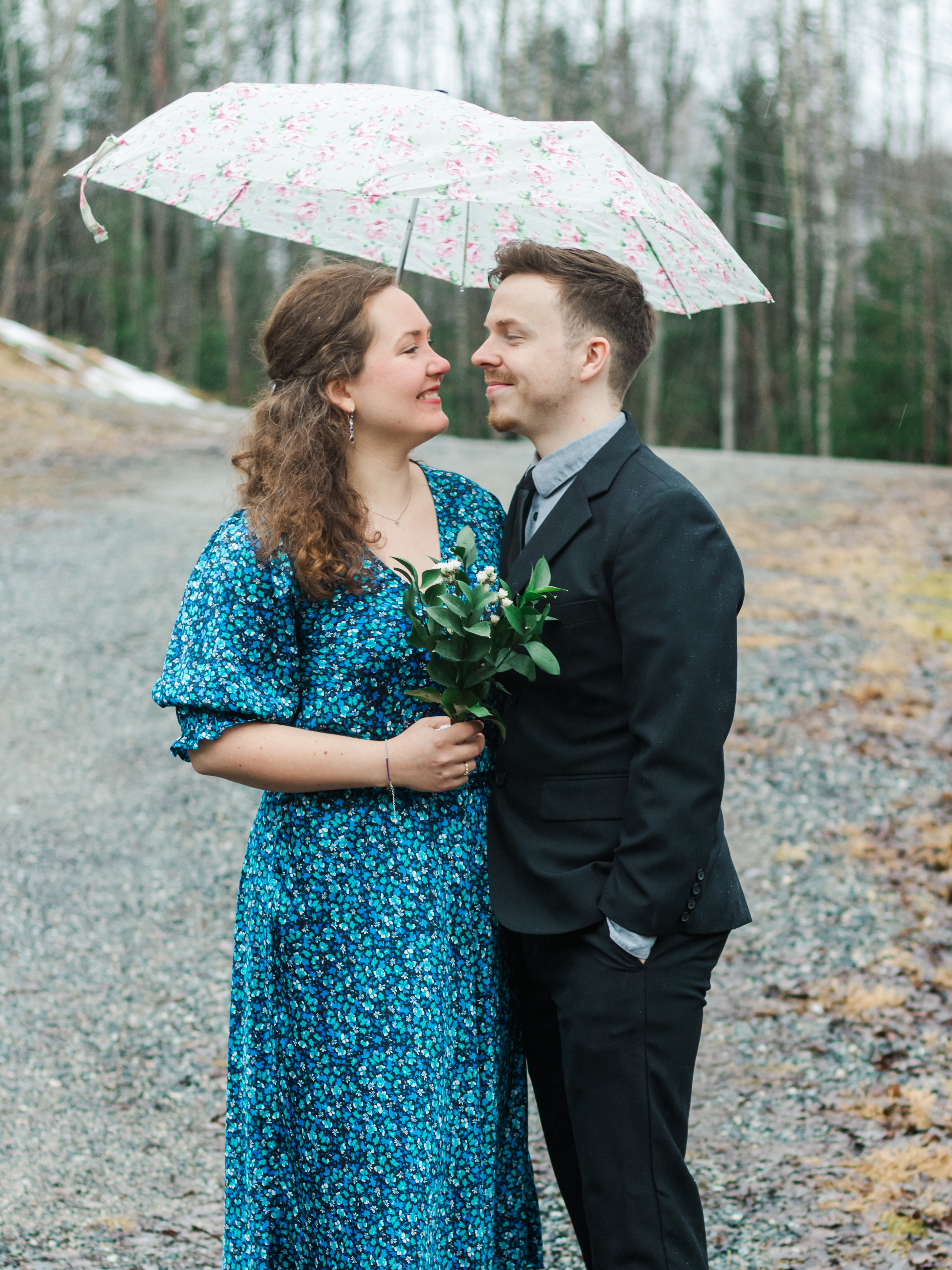 Couples smiling at each other under umbrella, couples photographer in mountains